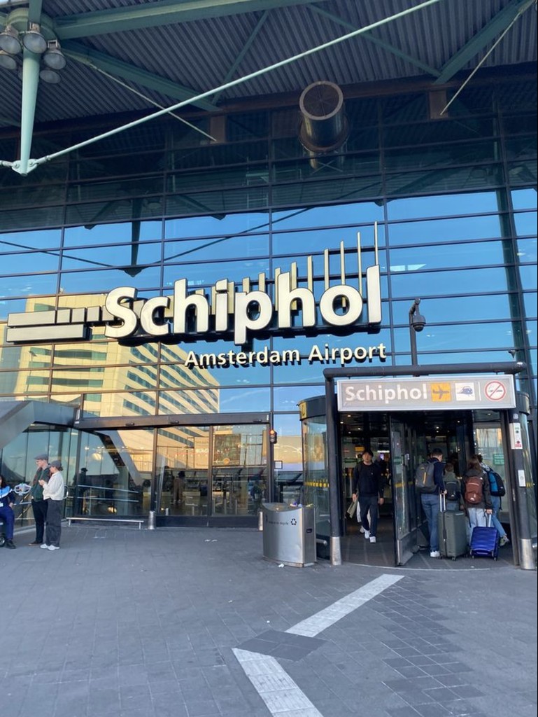 Exterior of Amsterdam Airport Schiphol with airport signage.