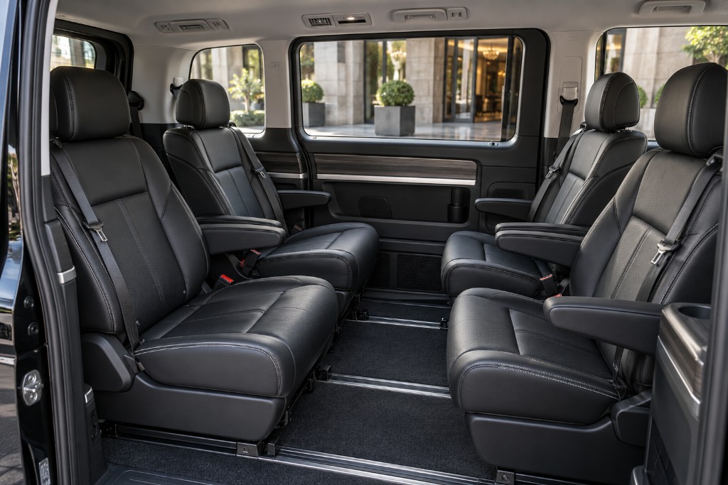 Passenger seating inside a private van prepared for business travel.