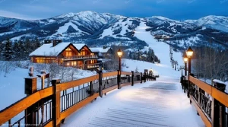 Luxury ski-in ski-out chalet at sunset with illuminated snowy slopes
